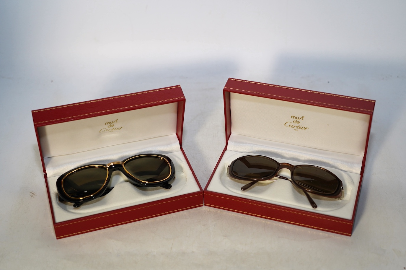 Two pairs of Must de Cartier sunglasses